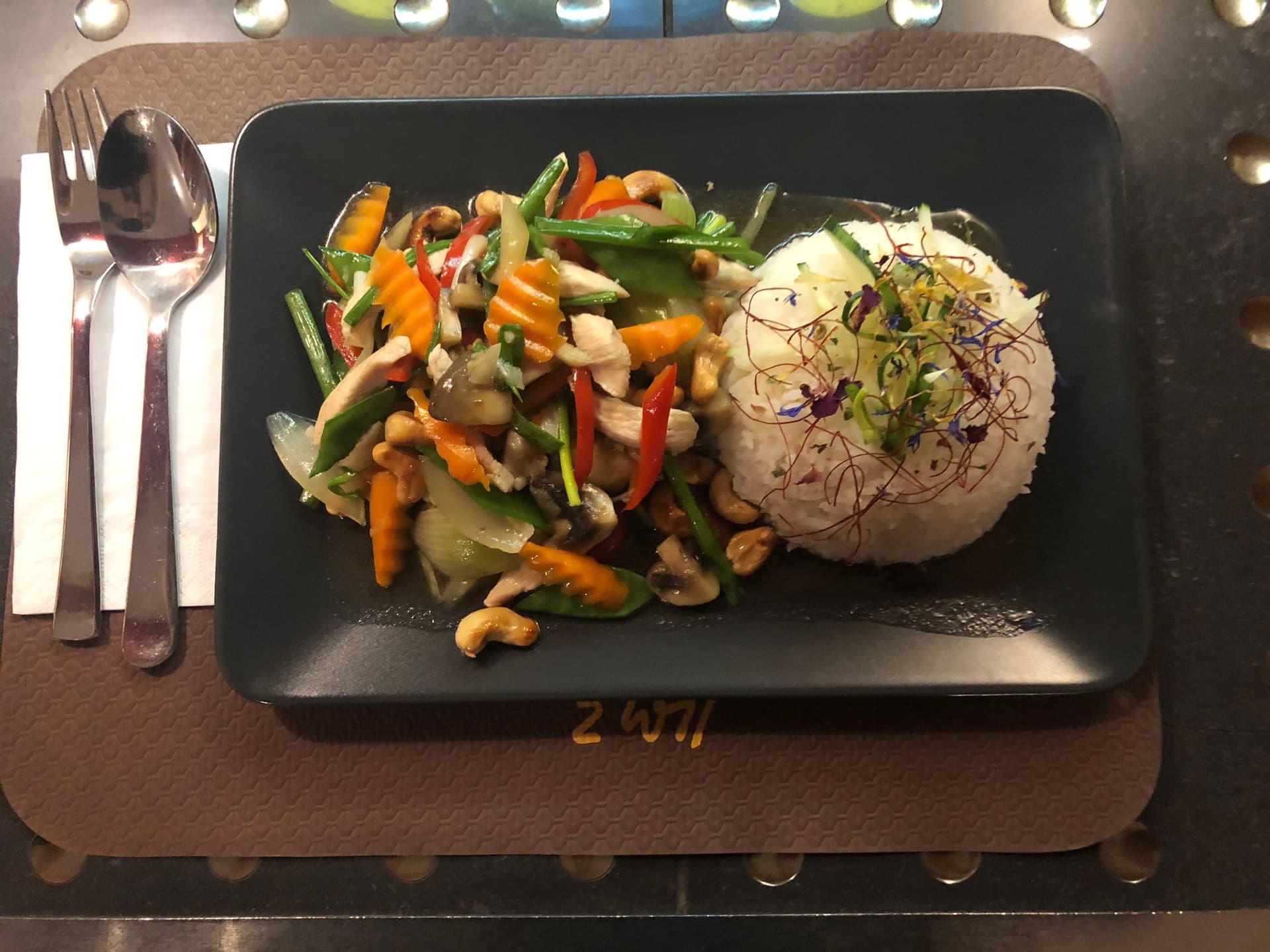 Frisch gekochtes Thai-Wokgericht mit Reis, angerichtet mit Blüten