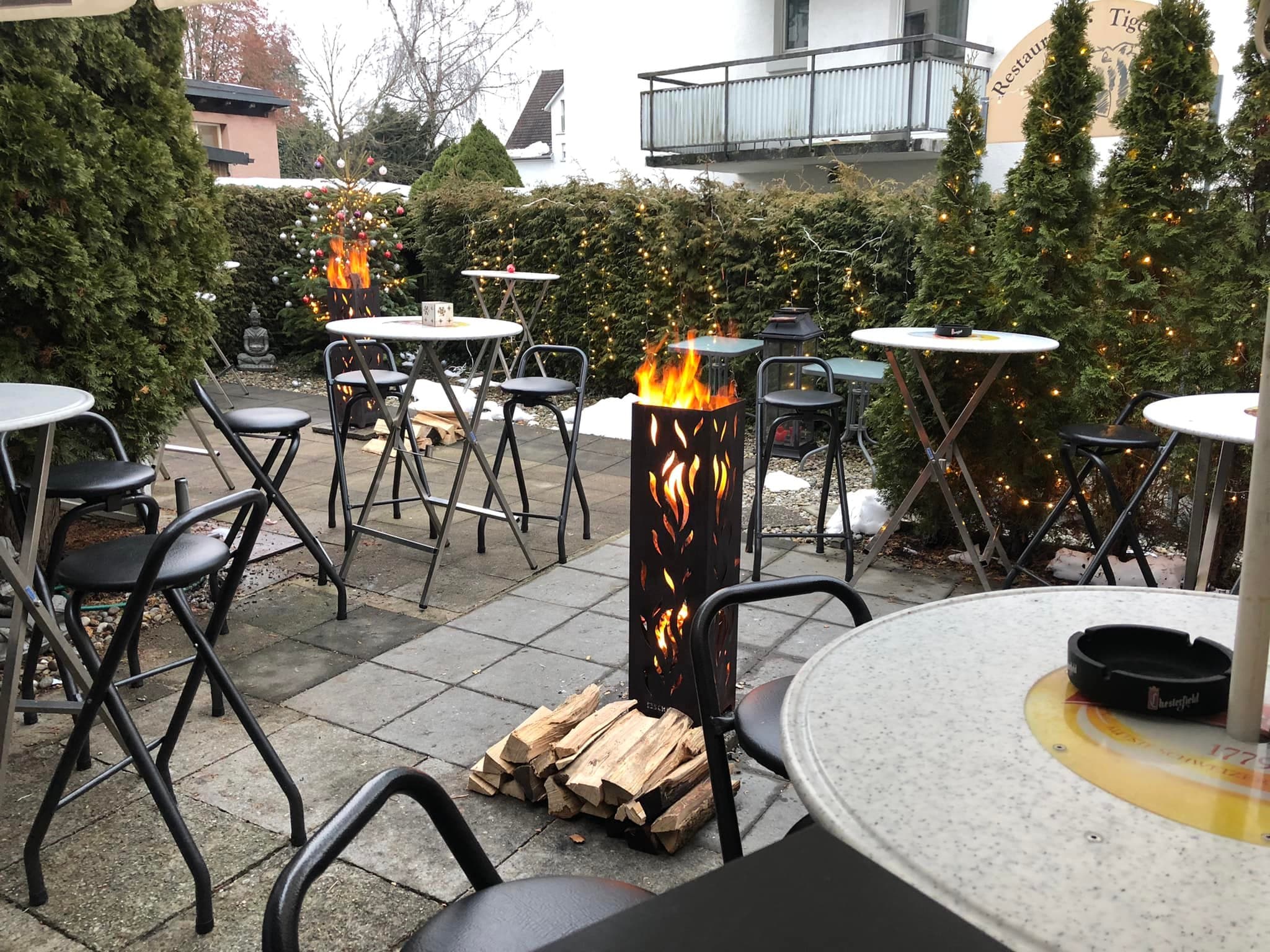 Gartenterrasse mit Feuerkörben am Abend